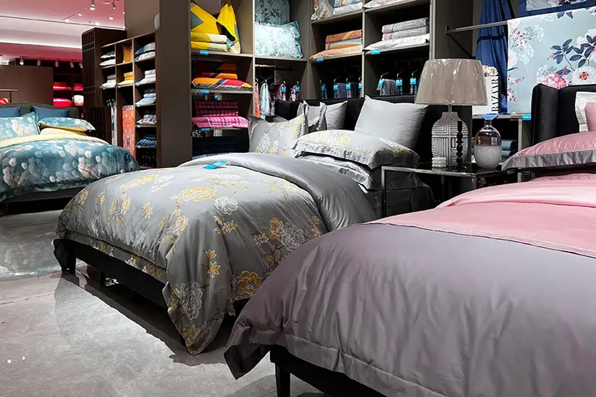 Beds, pillows and folded bedding displayed in a textile showroom