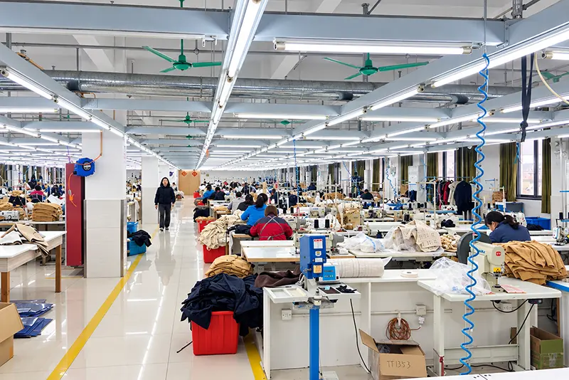 Central aisle between garment sewing stations, worktables and fabric bins