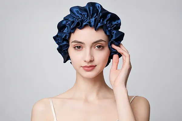 Navy sleep silk bonnet with a gathered edge shown on a model
