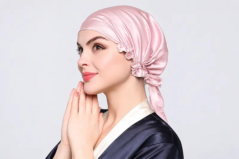 Pink silk bonnet on a model with a smooth front band and gathered back