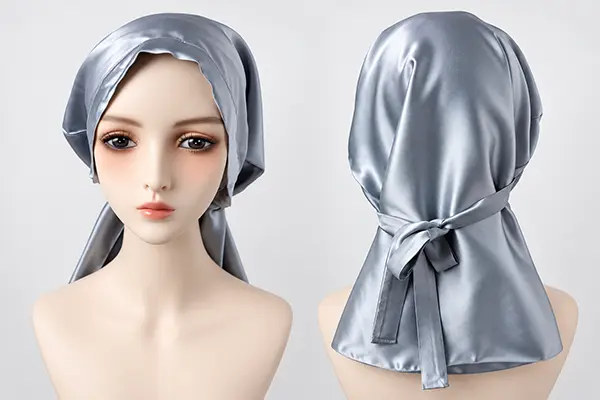 Silver silk bonnet on a mannequin, showing the front drape and wide tie at the back