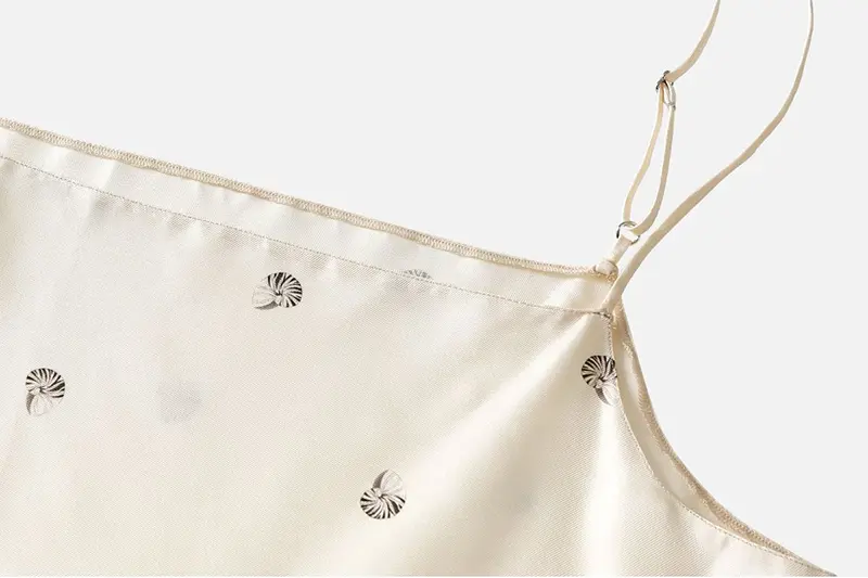 Adjustable shoulder strap and stitched neckline on an ivory printed silk dress