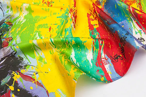 Draped silk scarf fabric with a bright yellow, green, red and blue abstract print