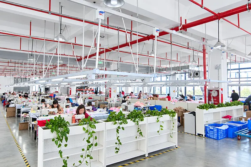Wide view of a textile workshop with sewing stations and fabric bins