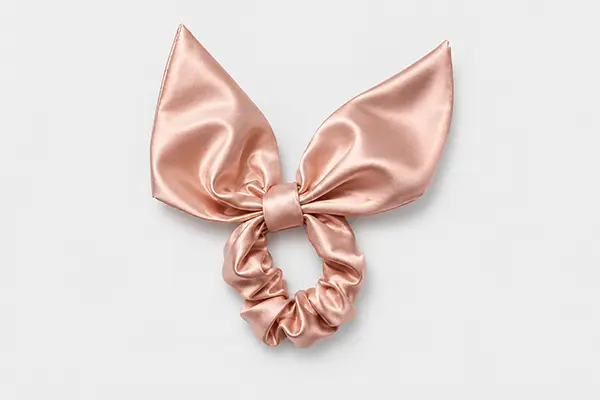 Rose pink silk scrunchie topped with a large pointed bow