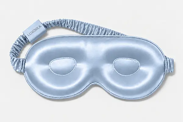 Pale blue silk sleep mask with raised eye cups and a gathered elastic strap