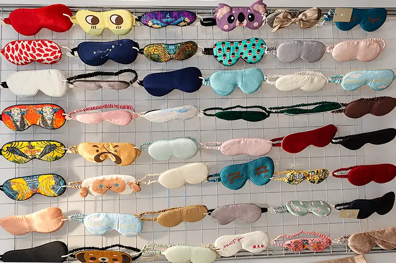Sleep masks in varied shapes, colors and prints arranged on a wall display