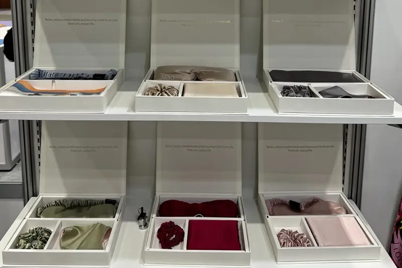 Open presentation boxes holding textile samples on showroom shelves